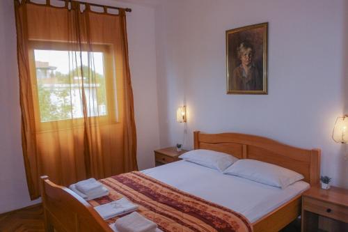 een slaapkamer met een bed en een raam bij Apartment Suzy in Vantačići