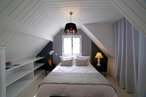 a bedroom with a bed in a attic with a window at Vila de Charme Suítes in Campos do Jordão