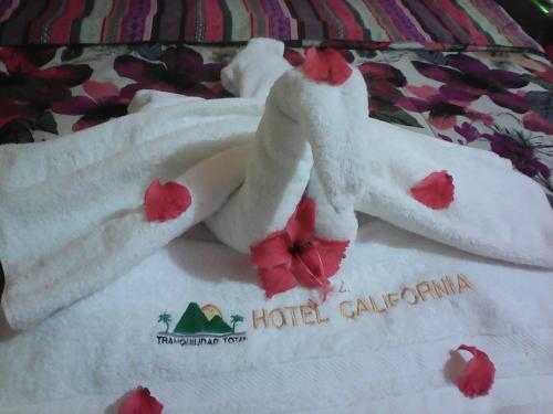 a pile of towels sitting on top of a bed at Hotel California in San Jorge