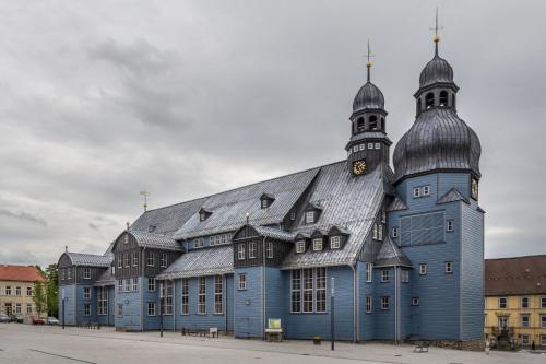 a large blue building with a clock tower on it at Haus am Oberen Eschenbacher Teich in Clausthal-Zellerfeld
