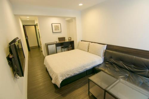 Habitación pequeña con cama y sofá en Zhongxiao Dunhua Homestay en Taipéi