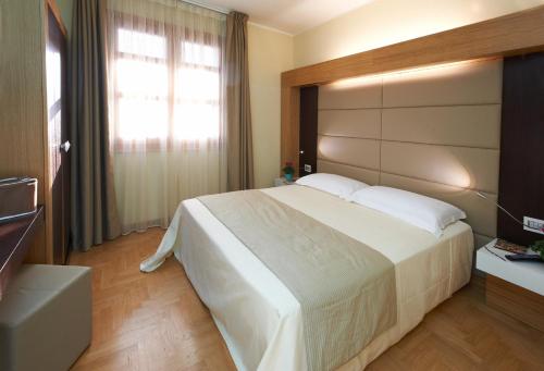 Un dormitorio con una cama grande y una ventana en Santa Caterina Resort, en Santa Caterina di Nardò