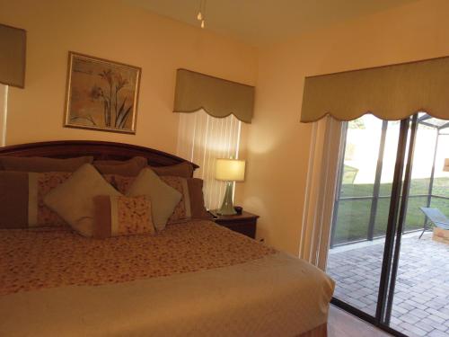 a bedroom with a bed and a sliding glass door at Kissimmee Area Pool Home in Orlando