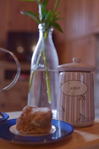 a pastry on a blue plate next to a vase at The Old School House in Clifden