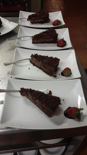 four plates of chocolate cake and strawberries on a table at Agriturismo Boschi in Reggiolo