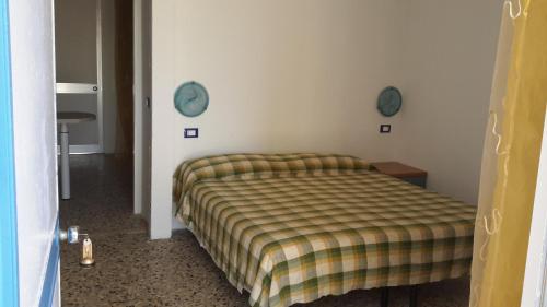 a bedroom with a bed with a striped blanket at Residence Hotel Baia del Sole in Capoliveri