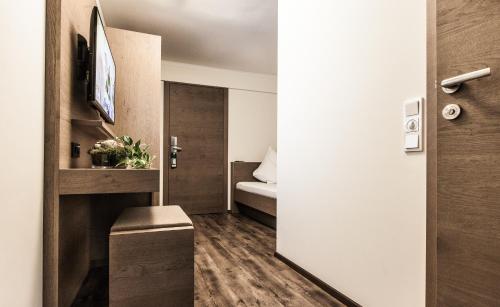a small apartment with a bedroom with a bed at Aktivhotel Tuxerhof in Zell am Ziller