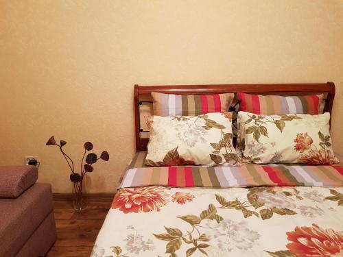 スタールイ・オスコルにあるСтудияのベッドルーム1室(カラフルな掛け布団と枕付きのベッド1台付)