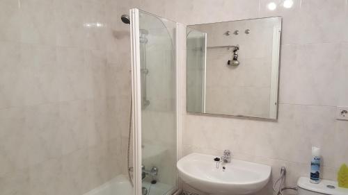 a bathroom with a shower and a sink and a mirror at Cascadas de la Marina in Denia