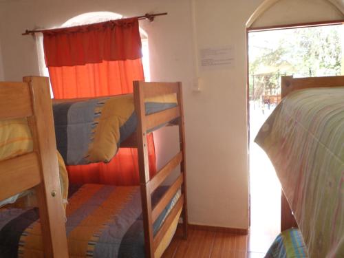 a room with two bunk beds and a window at Hostal Las Kañas in San Pedro de Atacama