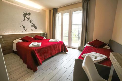 Habitación de hotel con 2 camas y manta roja en B&B Santa Maria Novella, en Florencia