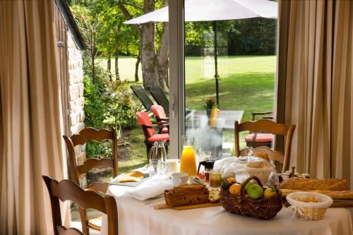 a table with a white table cloth and food on it at Cottages De La Bretesche in Missillac