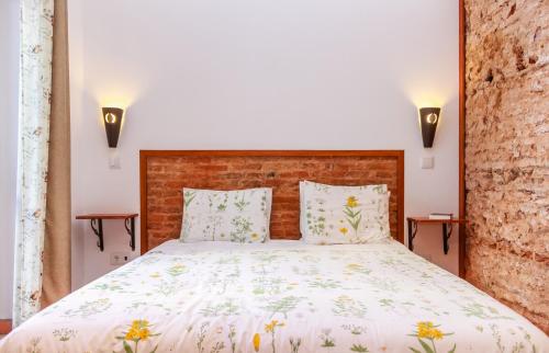 a bedroom with a large bed with two lamps at Casa da Tita in Salir