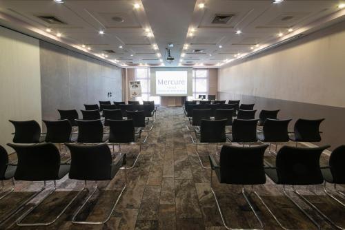 a conference room with chairs and a screen at Mercure Montpellier Centre Antigone in Montpellier