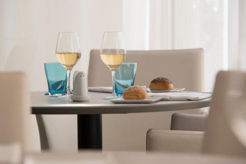 two glasses of wine and two donuts on a table at Mercure Montpellier Centre Antigone in Montpellier