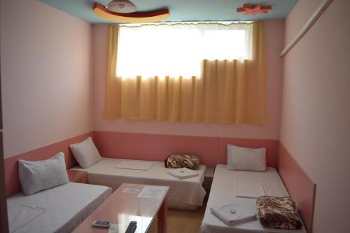 een kamer met 2 bedden en een raam bij Hotel Sianie in Tutrakan