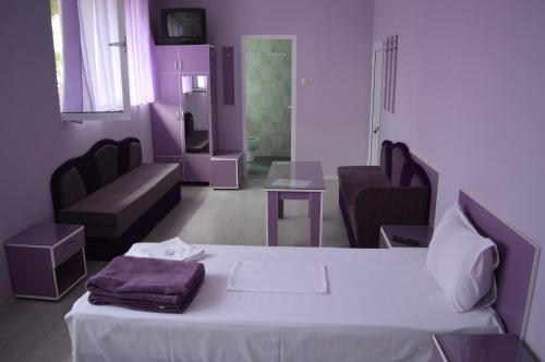 ein Schlafzimmer mit einem weißen Bett und ein Wohnzimmer in der Unterkunft Hotel Sianie in Tutrakan