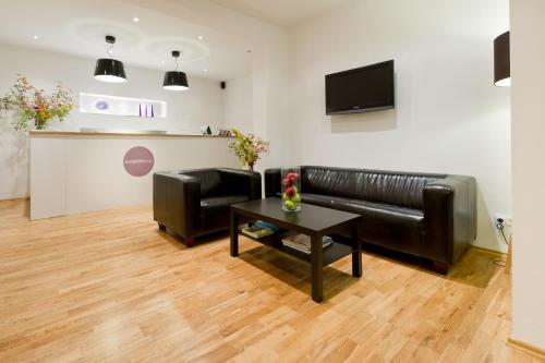 a living room with a black leather couch and a table at Burgblickhotel in Bernkastel-Kues