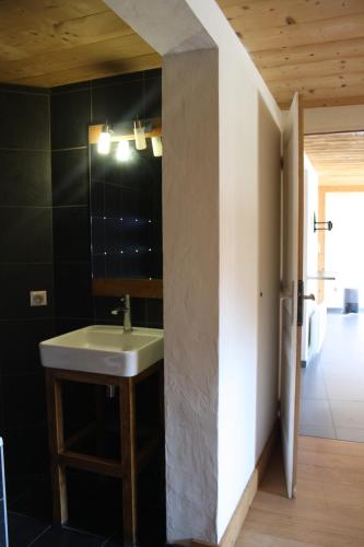 La salle de bains est pourvue d'un lavabo et d'un mur noir. dans l'établissement Le 995, à Morzine