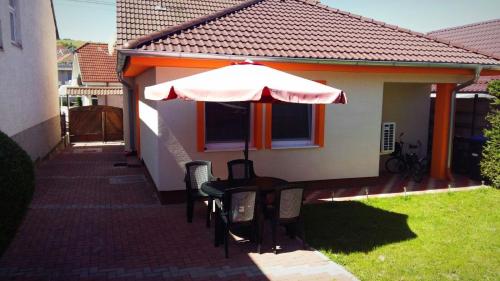 a table with an umbrella in the backyard of a house at Apartmán Marta in Banka