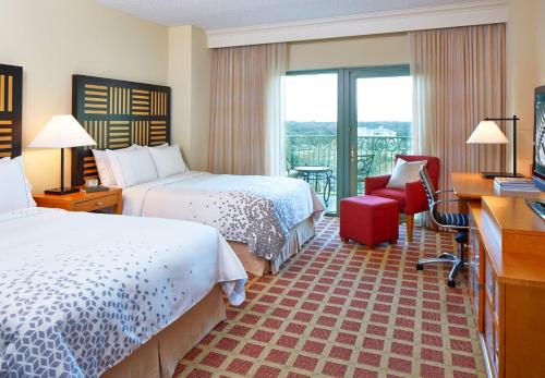 a hotel room with two beds and a balcony at World Golf Village Renaissance St. Augustine Resort in Saint Augustine