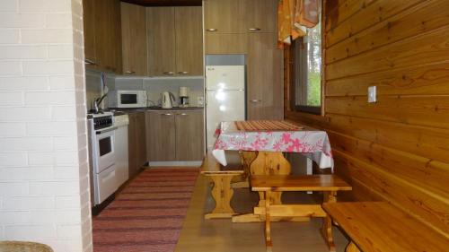 una piccola cucina con un tavolo e un frigorifero di Tiirantuvat a Juankoski