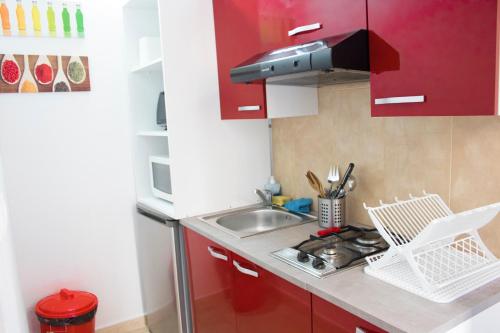 バレンシアにあるMurillo Apartmentの小さなキッチン(赤いキャビネット、シンク付)