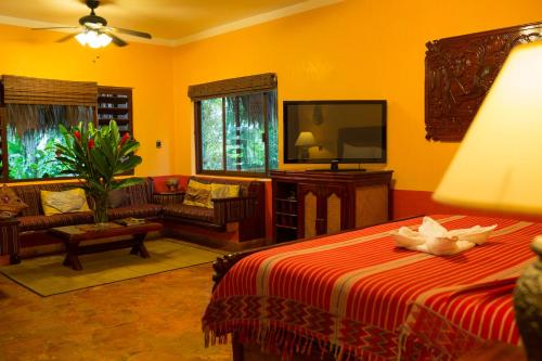 a living room filled with furniture and a tv at Hotel Boutique Quinta Chanabnal in Palenque
