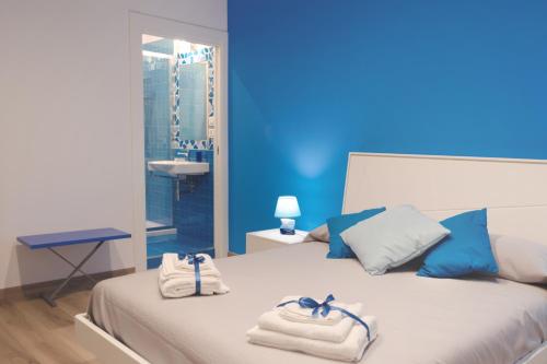 een blauwe kamer met 2 handdoeken op een bed bij Mare di Luci in Salerno