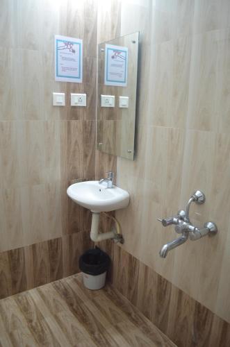 a bathroom with a sink and a mirror at Blackroots Serviced Apartments in Coimbatore