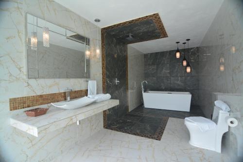 a bathroom with a tub and a sink and a toilet at Cabañas Luxury con Lagoon Club - Adults Only in Bacalar