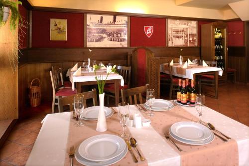 a restaurant with tables and chairs with plates and wine bottles at Penzion Budvarka in Hodonín