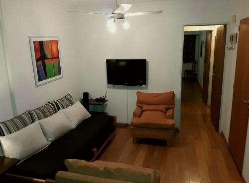 sala de estar con sofá y silla en Apartamento El Circulo en Rosario