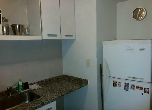 cocina con nevera blanca y fregadero en Apartamento El Circulo en Rosario