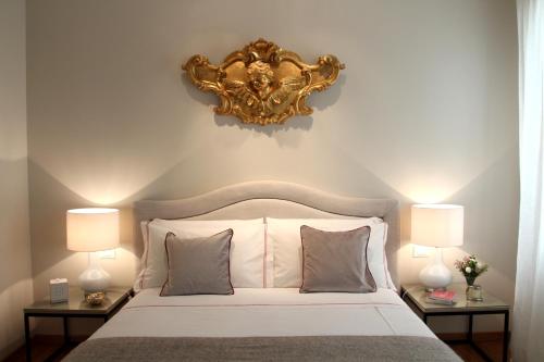 a bedroom with a white bed with two lamps at Primaluce in Venice