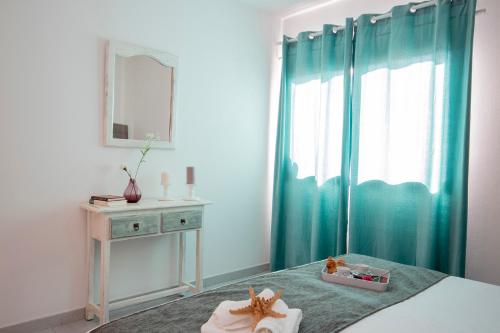 Schlafzimmer mit einem Bett mit grünen Vorhängen und einem Spiegel in der Unterkunft Apartamento Almirante VV in Arrecife