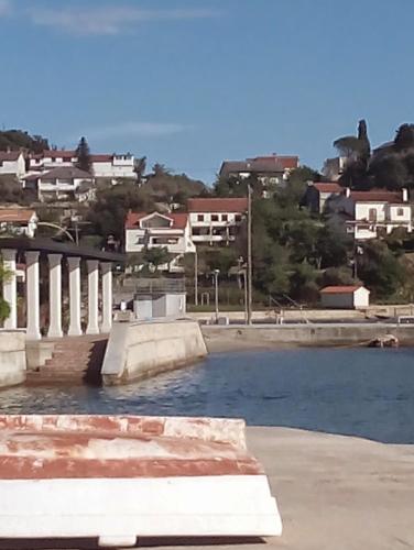 a body of water with buildings in the background at Vera Apartment in Rab