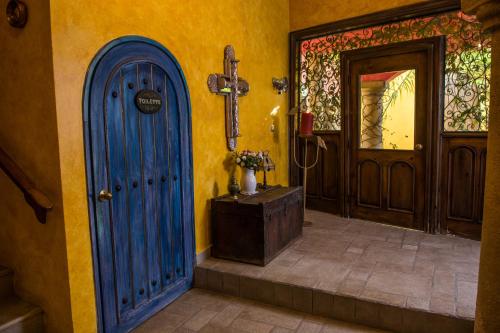 a church hallway with a blue door and a cross at Hacienda Boutique B&B and Spa Solo Adultos in Cozumel