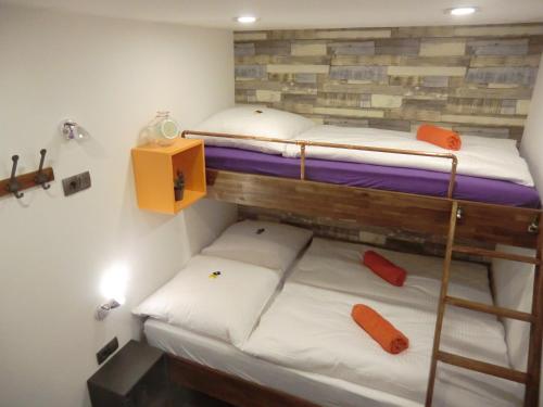 two bunk beds in a small room with white sheets at Cityflair Berlin Apartments & Rooms in Berlin