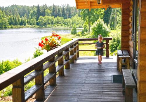 a little girl walking on a wooden bridge over a lake at Ezerkalni in Raiskums