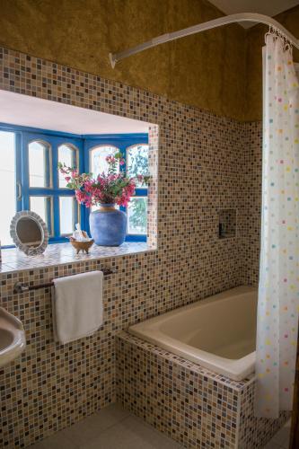 a bathroom with a bath tub and a sink at Hacienda Boutique B&B and Spa Solo Adultos in Cozumel