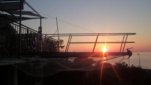 a boat in the water with the sunset in the background at Apartment Carpe Diem in Utjeha