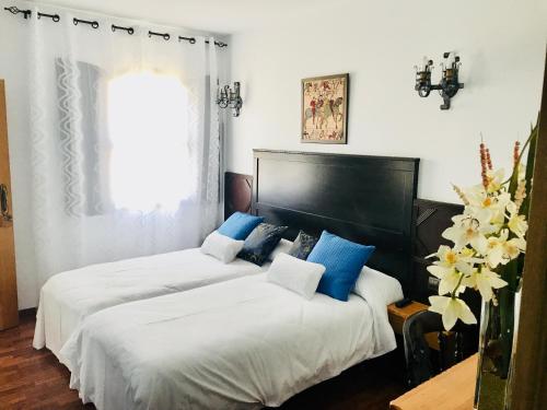two beds in a bedroom with blue and white at Hotel Castillo Bonavía in Pedrola