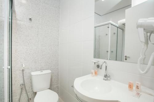 a bathroom with a toilet and a sink and a mirror at Travel Inn Express Hotels Brás in Sao Paulo