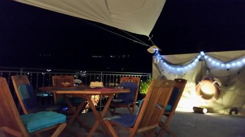 a table and chairs on a patio at night at Apartment Carpe Diem in Utjeha