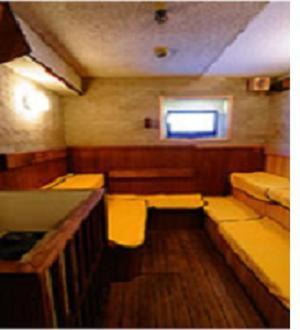 神戸市にあるカプセルホテル神戸三宮 (男性専用)のベンチと窓が備わる小さな客室です。