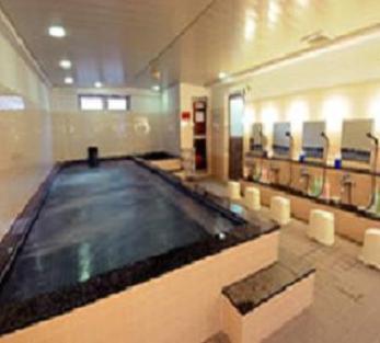 a large swimming pool in a large room with chairs at Capsule Hotel Kobe Sannomiya (Male Only) in Kobe