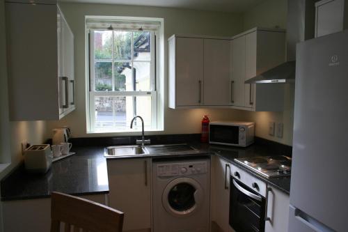 a kitchen with a sink and a washing machine at Highlands Apartment 2 in Shanklin