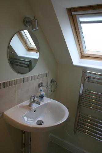 ein Bad mit einem Waschbecken und einem Spiegel in der Unterkunft Highlands Apartment 4 in Shanklin