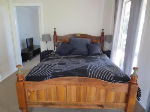 a bedroom with a large wooden bed with blue pillows at 3107 Estate in Irymple